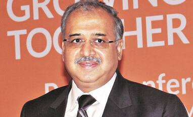 Dilip Shanghvi at a Sun Pharma conference in front of a backdrop reading Growing Together.